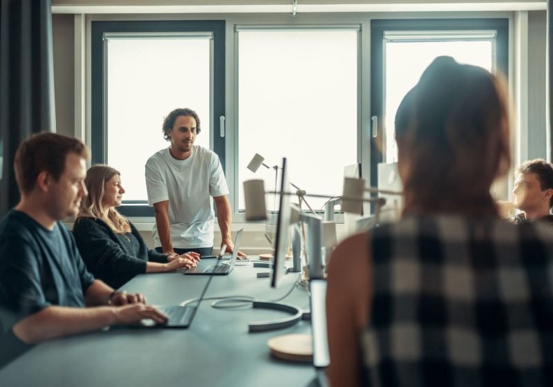 A diverse professional team engaged in discussion during a collaborative meeting in a modern office.