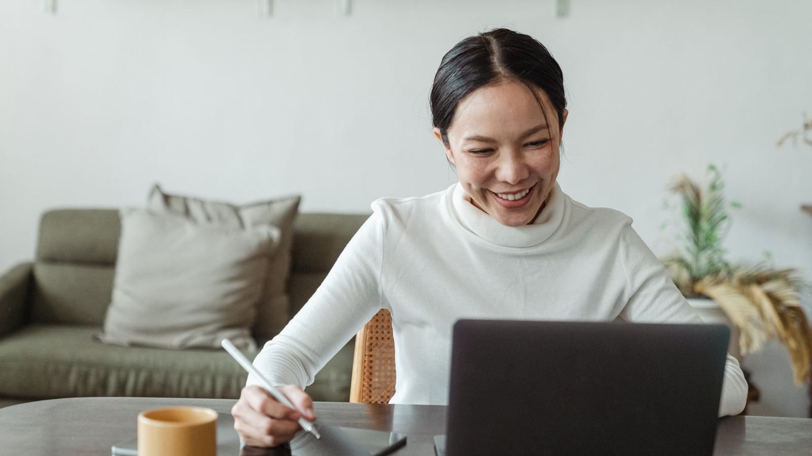 A person at home taking part in a video call with a clinician on a laptop for a virtual appointment.