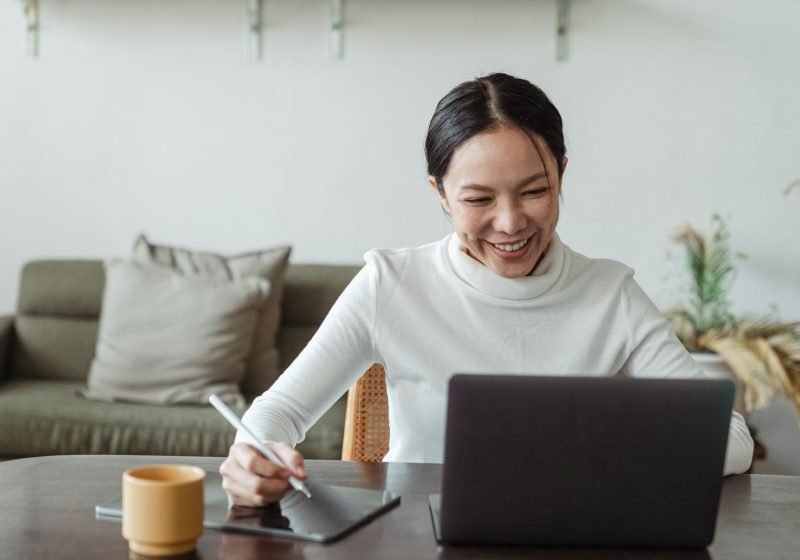 A person at home taking part in a video call with a clinician on a laptop for a virtual appointment.