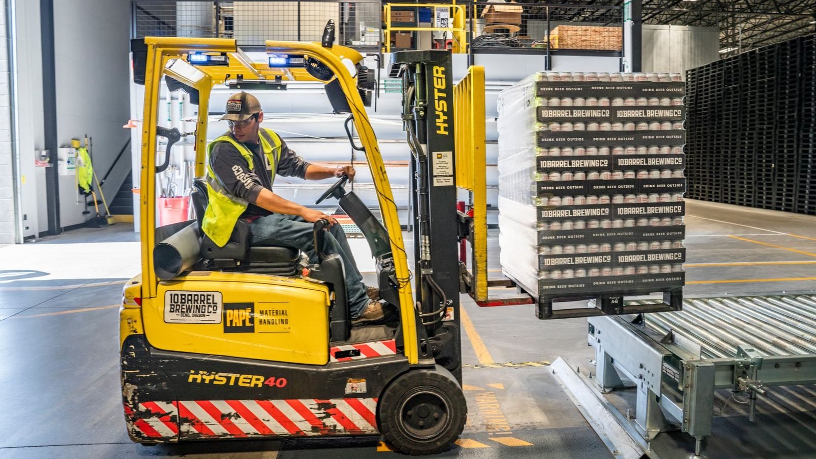 Warehouse operative driving a forklift to move stock in a distribution centre