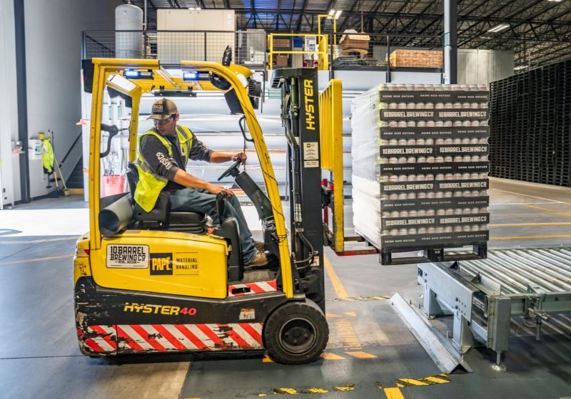 Warehouse operative driving a forklift to move stock in a distribution centre
