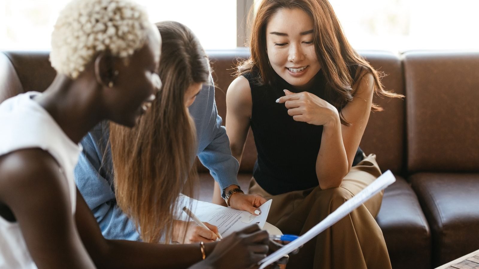 Diverse team of colleagues collaborating cheerfully over documents in a modern office