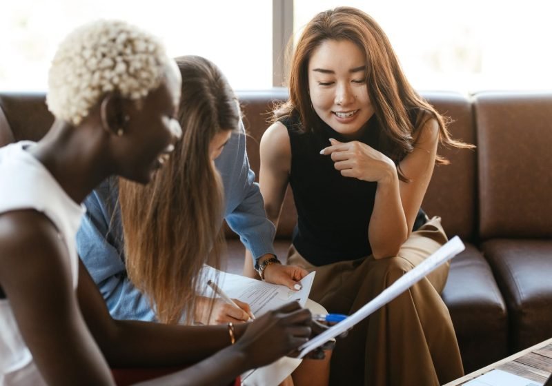Diverse team of colleagues collaborating cheerfully over documents in a modern office